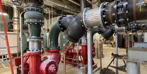 Electrical Engineering & Mechanical Upgrades featuring water pumps connected to heavy black industrial piping and valves in a mechanical room at CVG International Airport