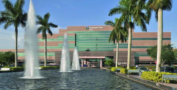 Exterior of the Cleveland Clinic in Weston, Florida building with palm trees and water fountains in front