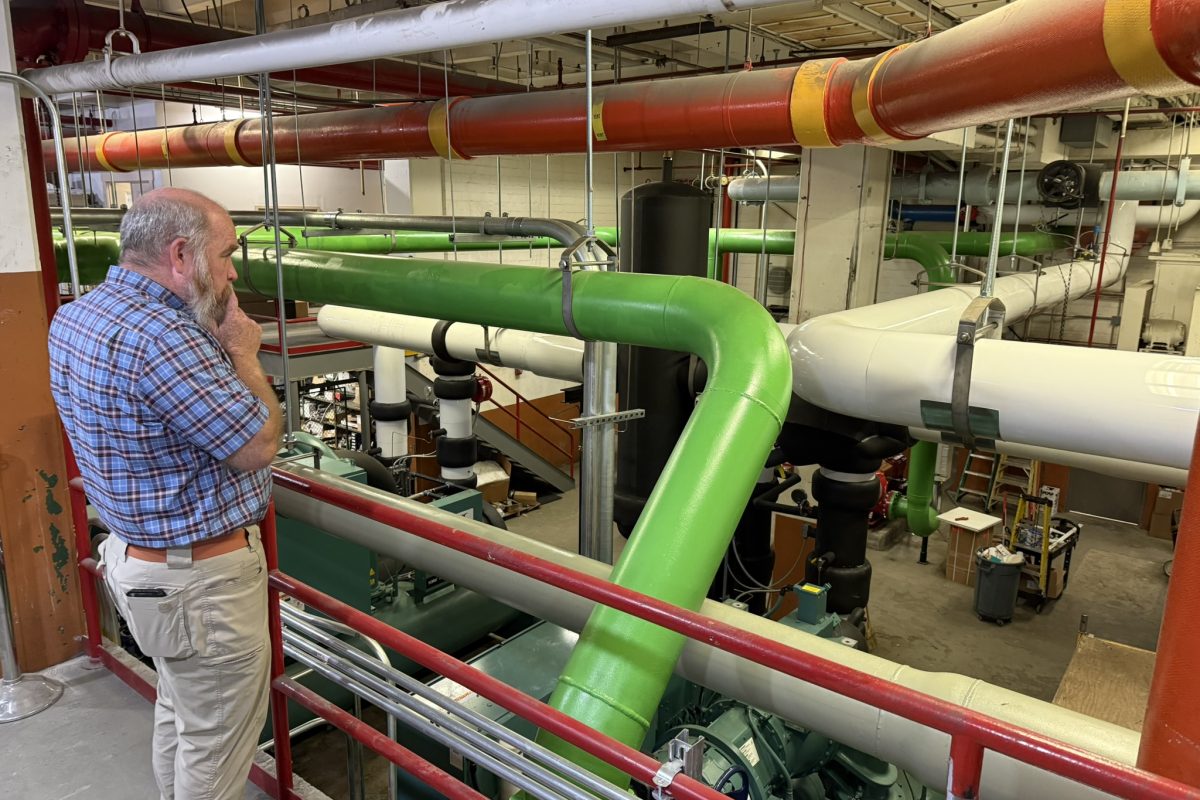 Kroger Chilled Water Plant Replacement with man standing on catwalk inspecting large color-coded industrial pipes