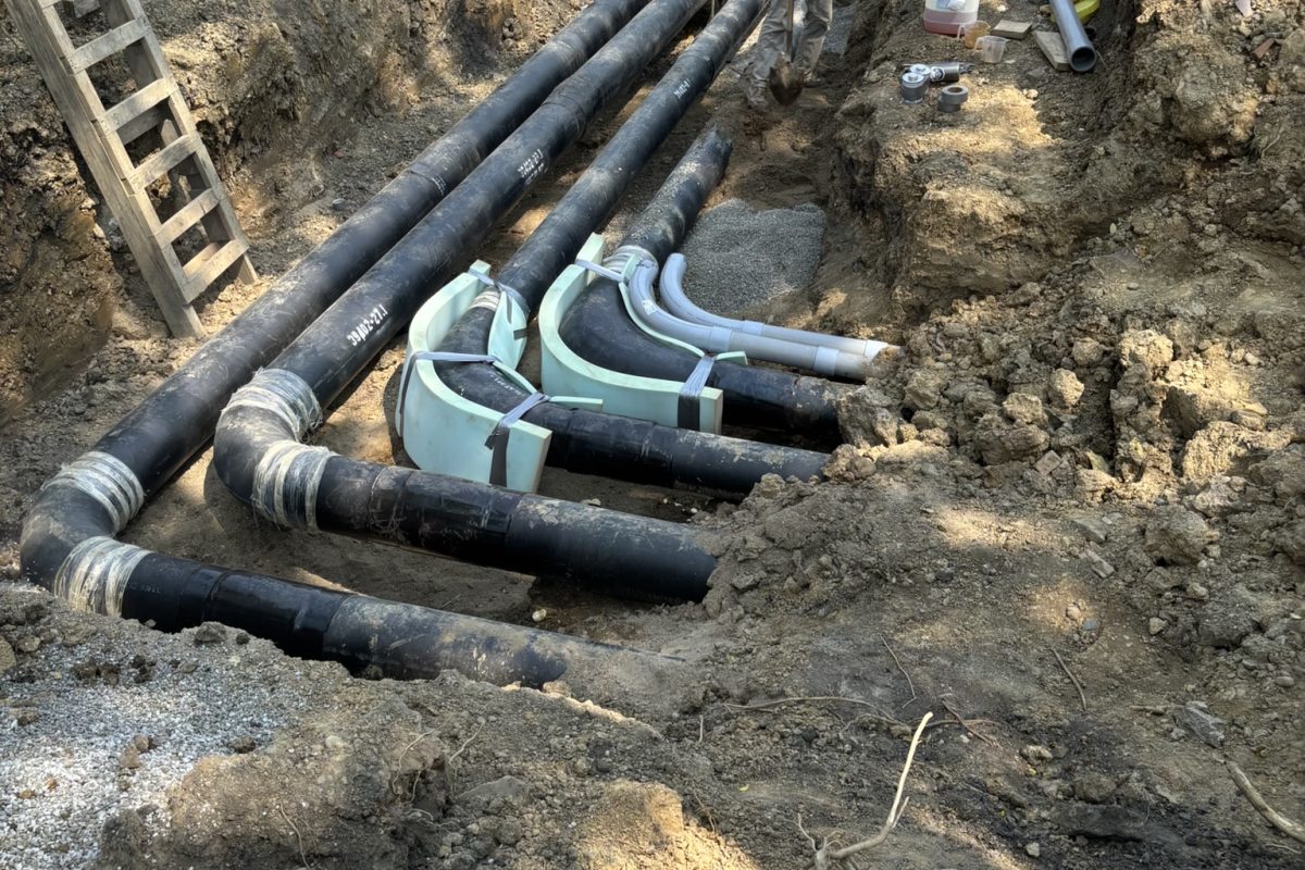 MEP Engineering Construction workers installing large underground pipes at Xavier University College of Medicine